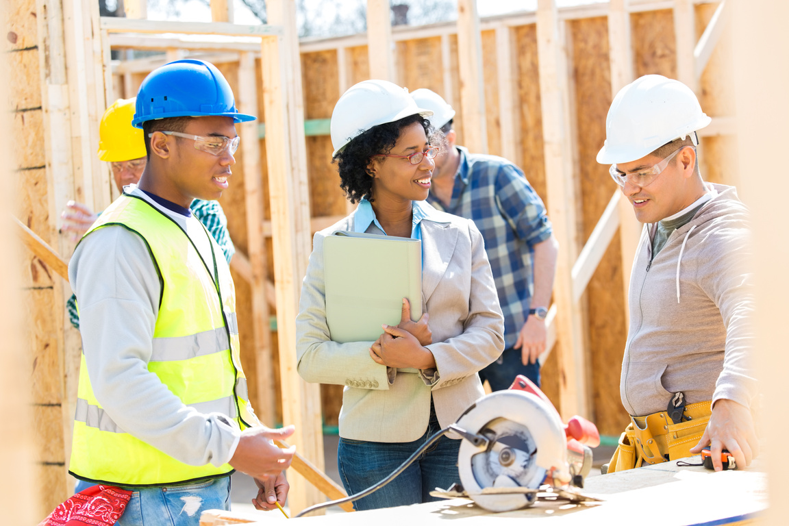 Construction workers meet with home builder